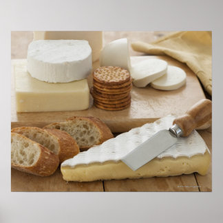 Various cheeses and bread on table poster