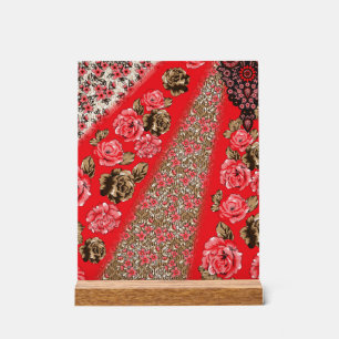 Vibrant red fabric featuring intricate floral and acrylic sign
