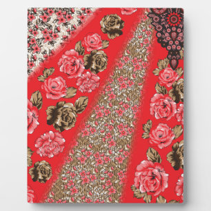 Vibrant red fabric featuring intricate floral and plaque