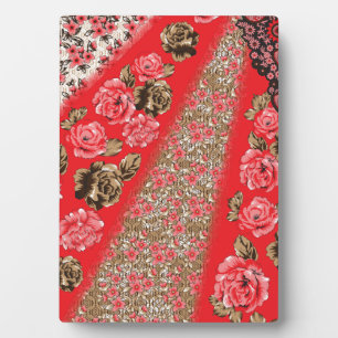 Vibrant red fabric featuring intricate floral and  plaque