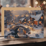 Victorian Christmas Village Vintage Winter Scene Holiday Card<br><div class="desc">This enchanting holiday card features a picturesque evening winter scene, showcasing a cosy village nestled under a snowy sky, with warmly lit cottages and charming stone bridges arching over a glistening river. The "Merry Christmas" message floats above this idyllic landscape, evoking feelings of peace and joy. With a solid colour...</div>