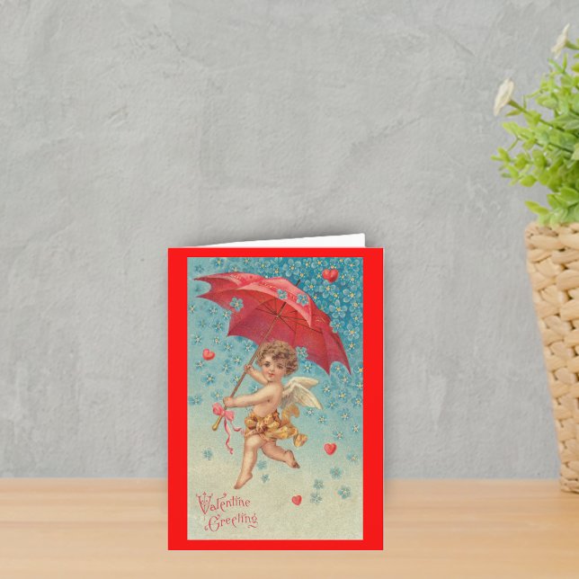 Victorian Valentine Cupid Hearts Umbrella Holiday Card (Victorian flying cupid red umbrella harts snowflakes on red Valentine's greeting card.)