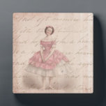 Vintage Ballerina Girl in a Pink Tutu Plaque<br><div class="desc">A darling vintage image of a ballerina in a pink tutu. The background is a faded shabby grunge style texture in an light antique beige with faded handwriting. Hints of faint pink surround the border. This ballet dancer is quaint and cute with rosy cheeks and her hands clasped together, her...</div>