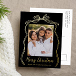 Vintage Bow Merry Christmas Black Photo Foil Holiday Postcard<br><div class="desc">Celebrate the holiday season with this charming Christmas postcard featuring your family's photo framed by a festive gold foil bow and ribbon on a black background. "Merry Christmas" is elegantly written in a charming gold foil handwritten script, with space to personalise your family name below. The back of the foil...</div>