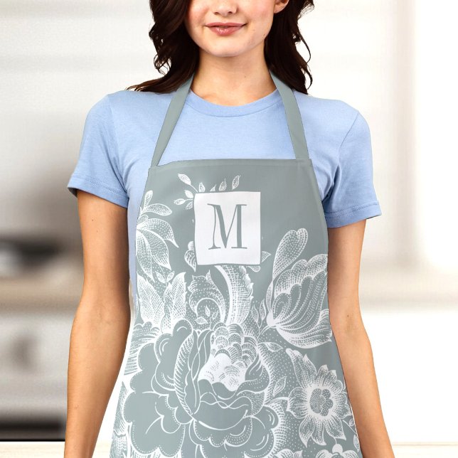 Vintage French Farmhouse Peony Monogram Light Grey Apron (A woman wearing a light blue shirt and a gray floral apron with the letter "M" on it)