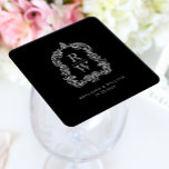 Vintage Monogram Crest Names Black White Wedding Square Paper Coaster<br><div class="desc">This elegant design features an ornate,  regency vintage-inspired crest of acanthus leaves framing two monogram initials in open serif font,  stacked vertically and separated by a thin horizontal line. Add the couple's names and wedding date below. The design and text are in white on a black background.</div>