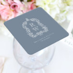 Vintage Monogram Crest Names Dusty Blue Wedding Square Paper Coaster<br><div class="desc">This elegant design features an ornate,  regency vintage-inspired crest of acanthus leaves framing two monogram initials in open serif font,  stacked vertically and separated by a thin horizontal line. Add the couple's names and wedding date below. The design and text are in white on a dusty blue background.</div>