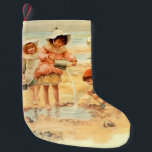Vintage Victorian Children At The Beach Fine Art Small Christmas Stocking<br><div class="desc">Capture the timeless innocence of a 19th-century summer with this beautiful "At the Beach" antique fine art print. This charming graphic artwork features a group of Victorian children in period dress—complete with sunbonnets and sailor collars—happily playing in the sand with buckets, shovels, and a toy sailboat. The soft, weathered palette...</div>