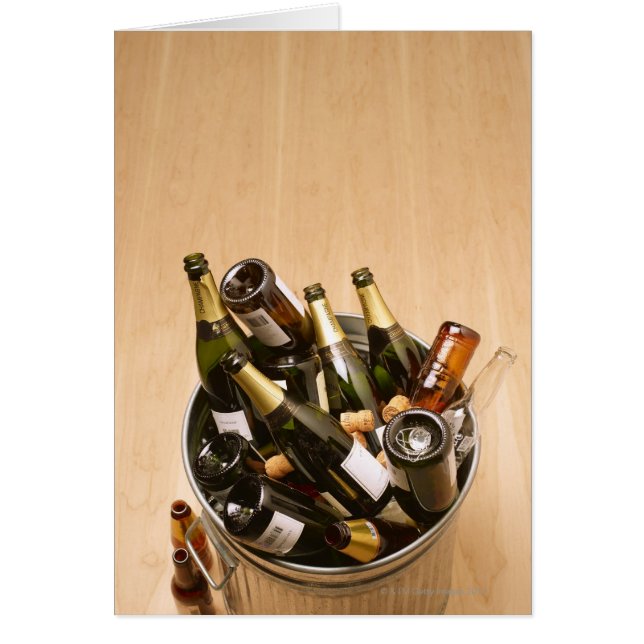 Waste bin full of empty champagne bottles on (Front)