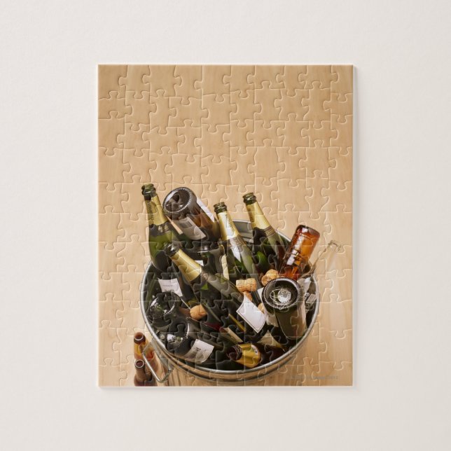 Waste bin full of empty champagne bottles on jigsaw puzzle (Vertical)