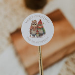 Watercolor Owl Family Personalised Merry Christmas Classic Round Sticker<br><div class="desc">These cute holiday stickers feature a family of three adorable watercolor owls in cosy knitted caps,  scarves and sweaters. The words "Merry Christmas" appear in beige serif font,  with your family's name below.</div>