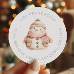 Watercolor Pink Snowman Christmas Return Address Classic Round Sticker<br><div class="desc">This holiday return address sticker features a pink and beige watercolor snowman in a cosy knitted scarf and hat. Add your family's name around the top edge in beige serif font and your address below.</div>