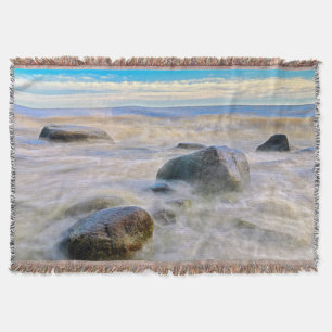 Waves crashing on shoreline rocks throw blanket