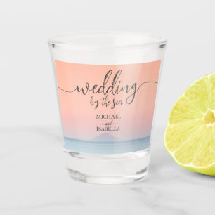 Wedding by the sea under peachy sky sunset shot glass