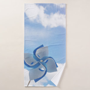 White and blue handheld windmill under cloudy skie bath towel