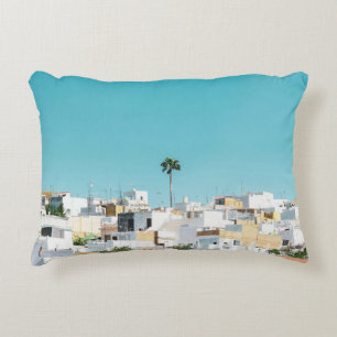 White and brown concrete houses under blue sky in decorative cushion