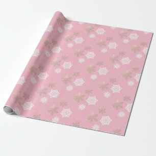 white and gold snowflakes against pale pink wrapping paper