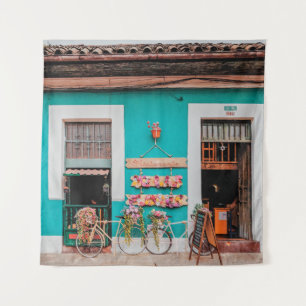 WHITE BICYCLE PARKED BESIDE TEAL PAINTED CONCRETE TAPESTRY