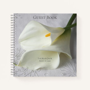 White calla lilies on linen notebook