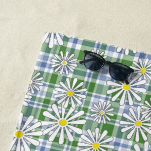 White chamomile flowers on a green blue checkered  beach towel