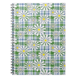 White chamomile flowers on a green blue chequered notebook