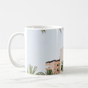 WHITE CONCRETE BUILDING BESIDE GREEN PALM TREE UND COFFEE MUG