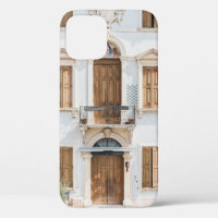 WHITE CONCRETE BUILDING WITH WOODEN DOORS AND WIND