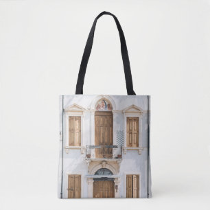 WHITE CONCRETE BUILDING WITH WOODEN DOORS AND WIND TOTE BAG