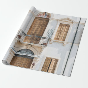 WHITE CONCRETE BUILDING WITH WOODEN DOORS AND WIND WRAPPING PAPER