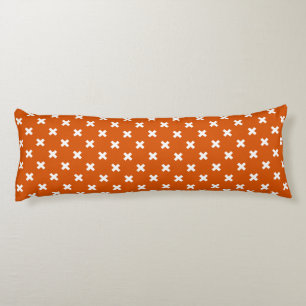 White cross stitches on burnt orange body cushion