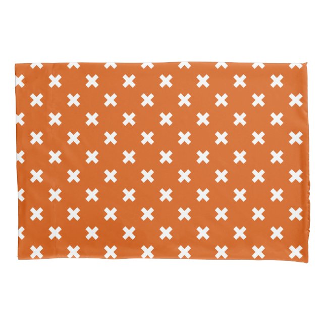 White cross stitches on burnt orange pillowcase (Front)