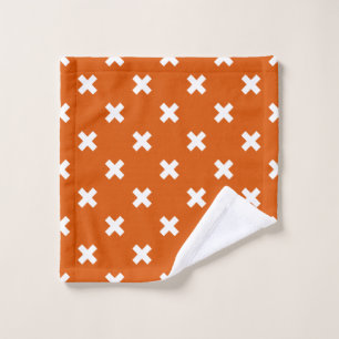 White cross stitches on burnt orange wash cloth