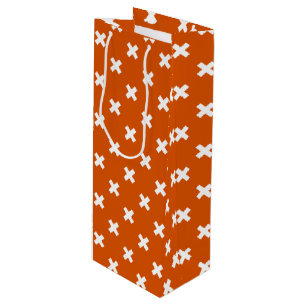 White cross stitches on burnt orange wine gift bag