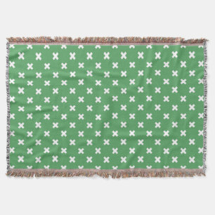 White cross stitches on green throw blanket