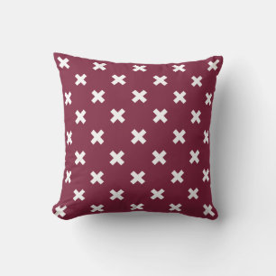 White cross stitches on mulberry cushion