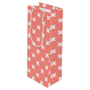 White cross stitches on peach wine gift bag