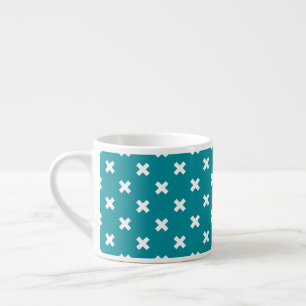 White cross stitches on teal espresso cup