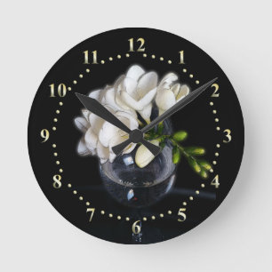 white freesia in a glass round clock