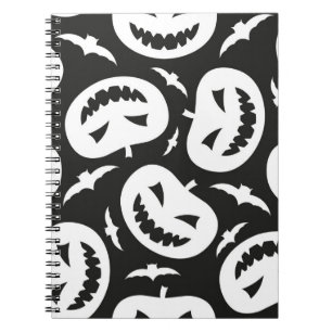 White halloween pumpkins and bats isolated on blac notebook