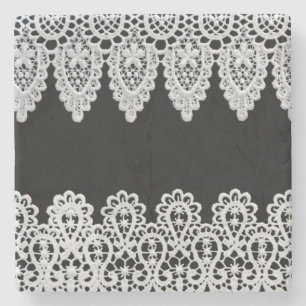 White lace forms a delicate border against black stone coaster