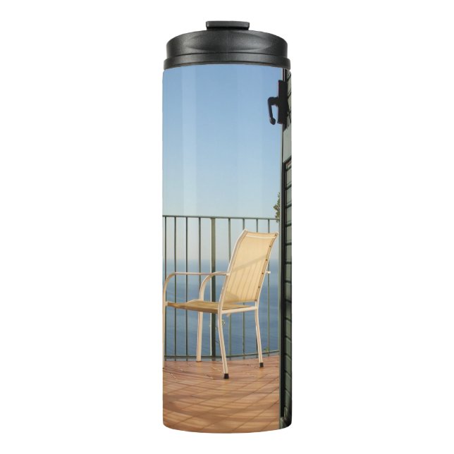 White metal armchair beside fence in the morning thermal tumbler (Front)