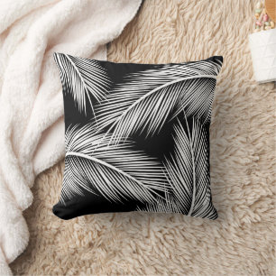 White palm leaves on black colour background cushion