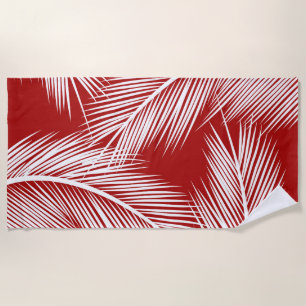 White palm leaves on red colour background beach towel