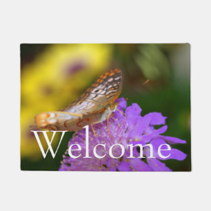 White peacock butterfly on purple bloom doormat