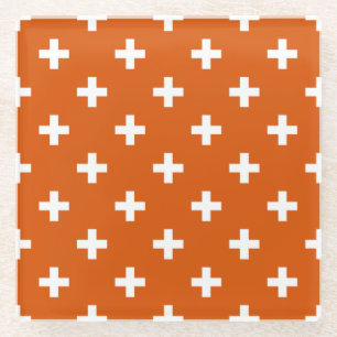 White polka crosses on burnt orange glass coaster