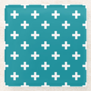 White polka crosses on teal glass coaster