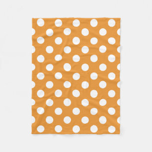 White polka dots on amber fleece blanket