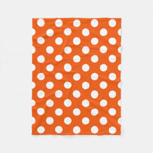 White polka dots on orange fleece blanket
