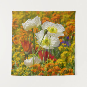 White poppies growing around the colourful flowers tapestry