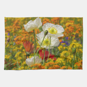 White poppies growing around the colourful flowers tea towel